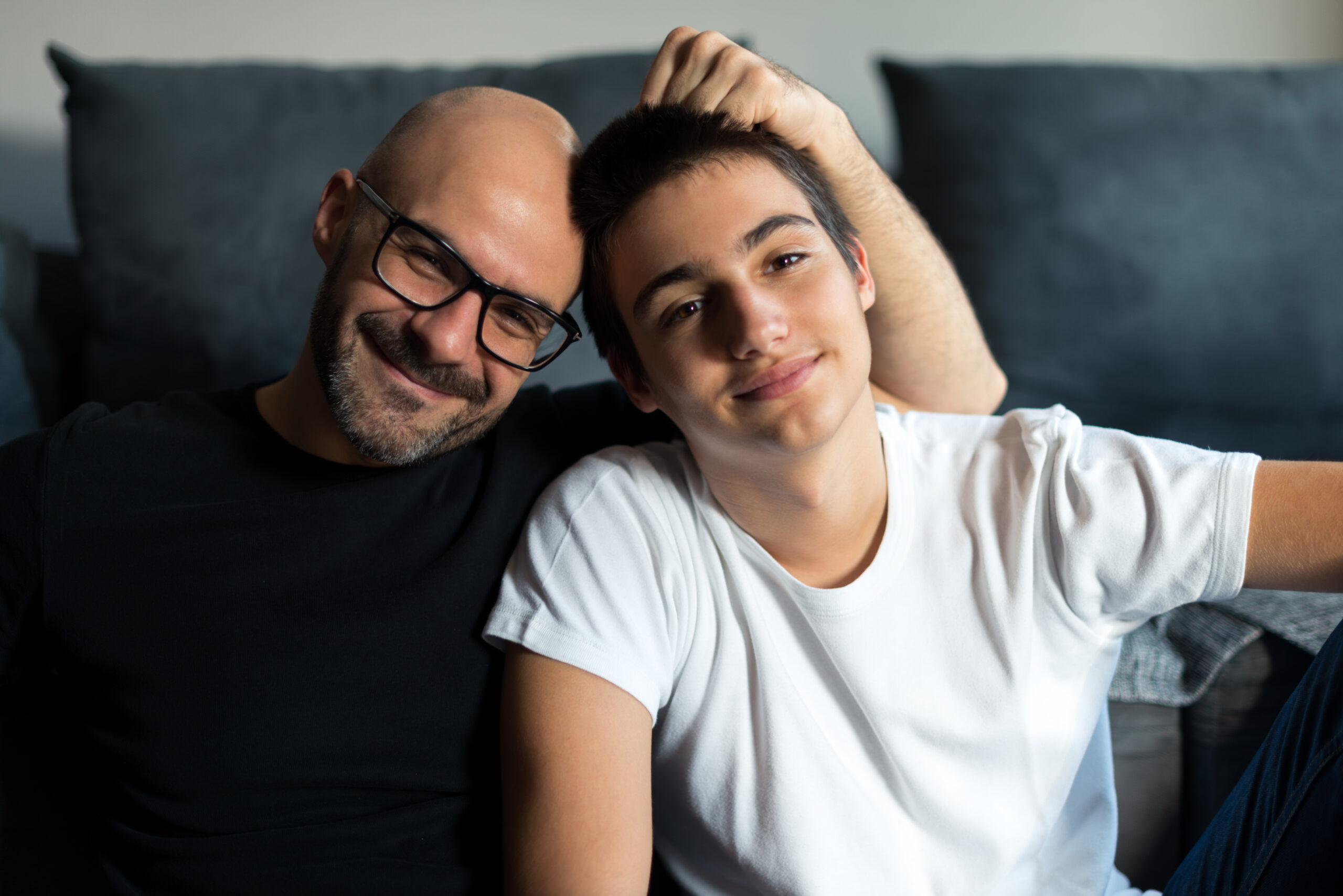 Portrait of father and son bonding in a living room.