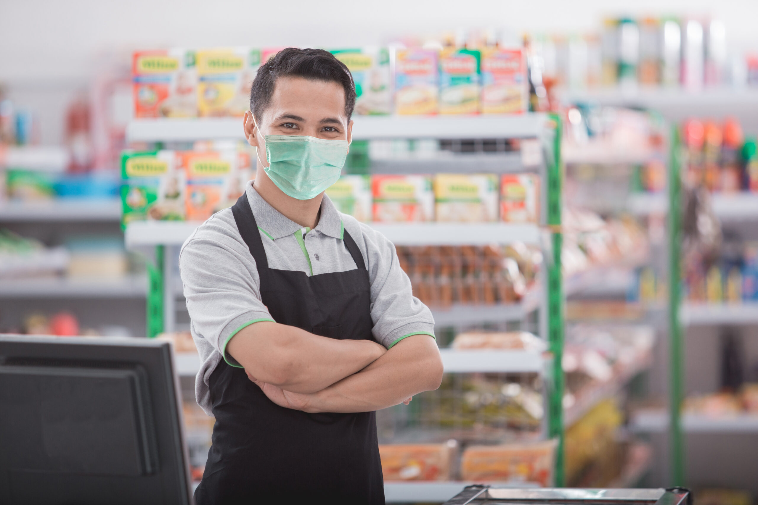 Male retail cashier wearing mask