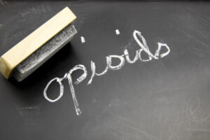 "Opioids" is written in chalk on a blackboard with an eraser. | « Opioïdes » est écrit à la craie sur un tableau noir avec une gomme.