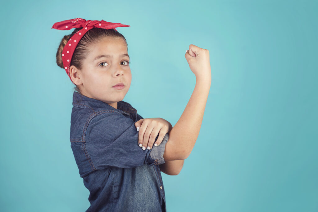 Child dressed as Rosie the Riveter on blue background | Enfant déguisé en Rosie la riveteuse sur fond bleu