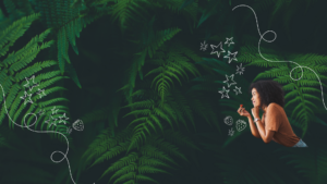 Woman holding strawberry in front of ferns