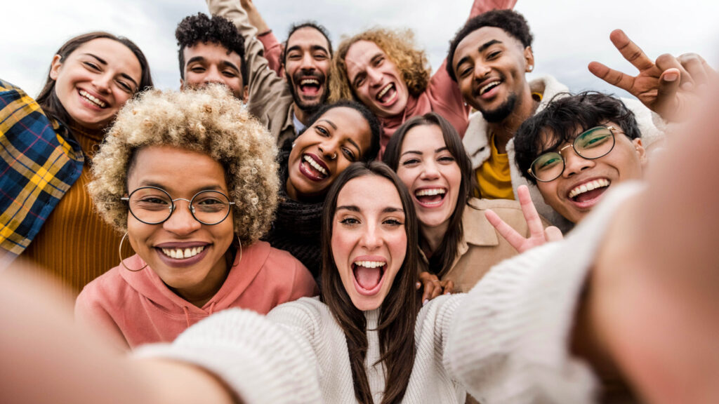 Multiracial friends taking big group selfie shot smiling at camera - Laughing young people standing outdoor and having fun - Cheerful students portrait outside school - Human resources concept | Amis multiraciaux prenant un grand selfie de groupe tourné en souriant à la caméra - Rire des jeunes debout à l'extérieur et s'amuser - Portrait d'étudiants joyeux à l'extérieur de l'école - Concept de ressources humaines