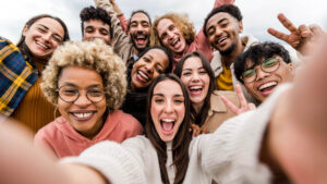 Multiracial friends taking big group selfie shot smiling at camera - Laughing young people standing outdoor and having fun - Cheerful students portrait outside school - Human resources concept | Amis multiraciaux prenant un grand selfie de groupe tourné en souriant à la caméra - Rire des jeunes debout à l'extérieur et s'amuser - Portrait d'étudiants joyeux à l'extérieur de l'école - Concept de ressources humaines