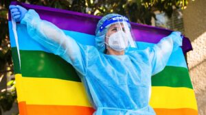 COVID healthcare worker in PPE with pride flag