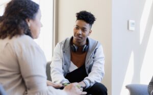 young man speaks with a counselor