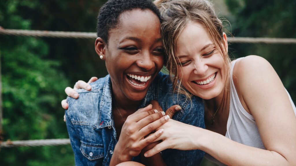 Two women are hugging and laughing