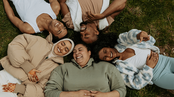 Friends lying in the grass and smiling