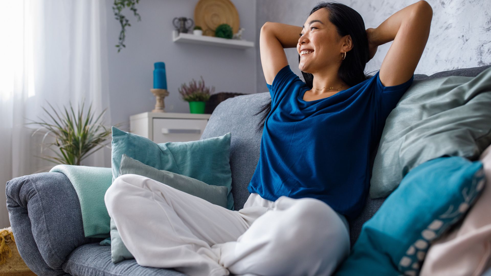 A woman is sitting on a couch in her living room.