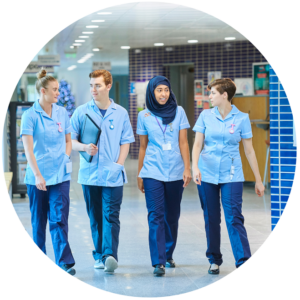 A group of health-care workers walking through a hospital hallway