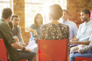 A diverse group of professionals sitting in chairs during a business meeting.