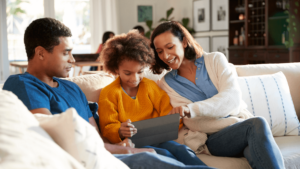 Parents looking over their child's shoulder while using an iPad.