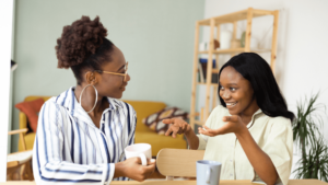 Two friends drinking coffee and having a conversation.