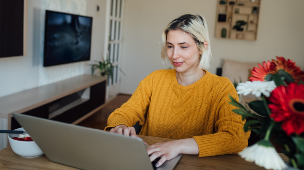 A woman, at home using a laptop