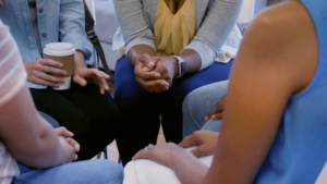 Personnes dans un cercle avec les mains jointes