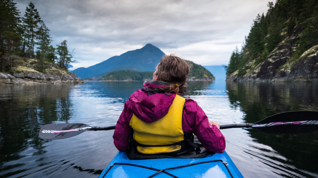 A kayaking woman enjoying nature on a still lake