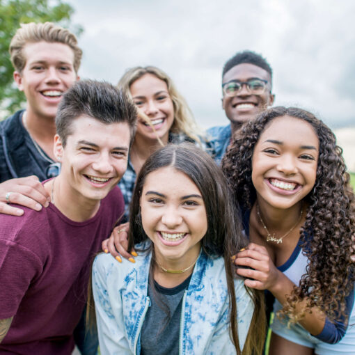 A group of people in a park, smiling at the camera.