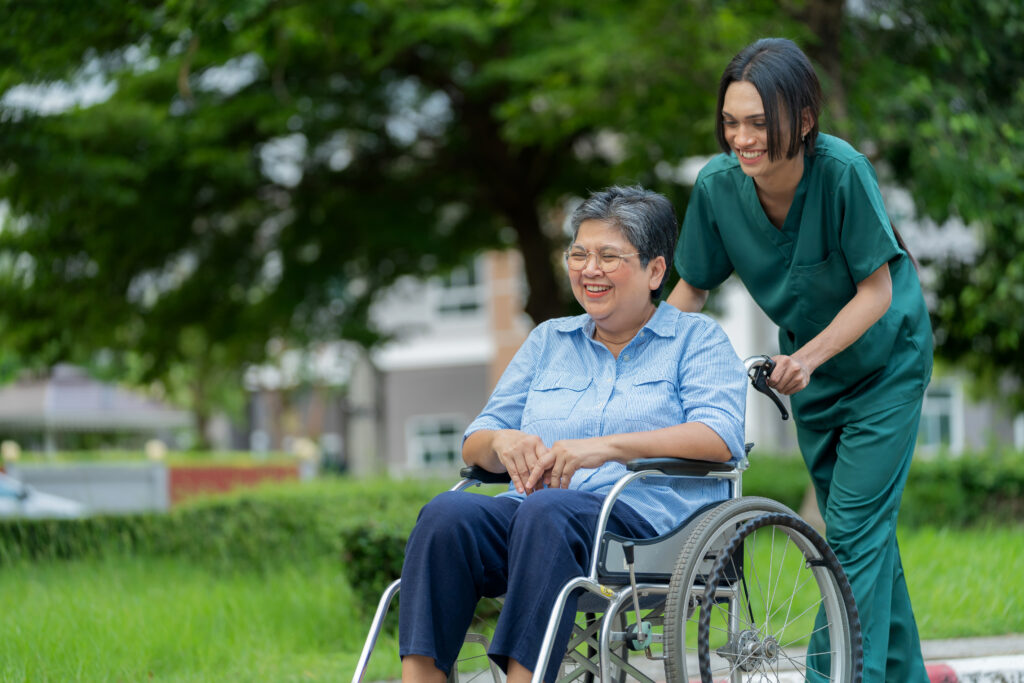 A care provider enjoying a conversations with a senior in a wheelchair