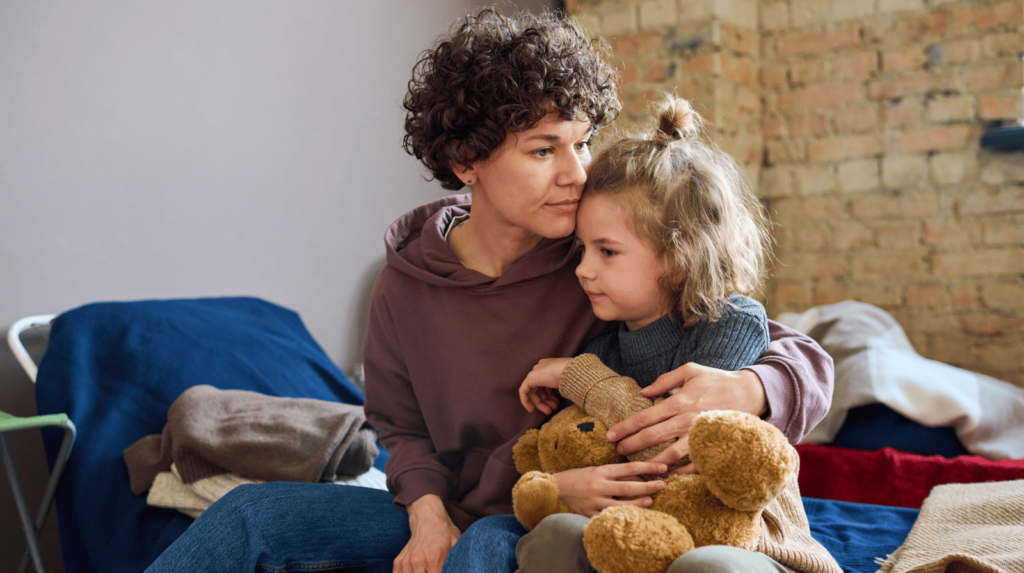 A woman comforting her daughter at a shelter