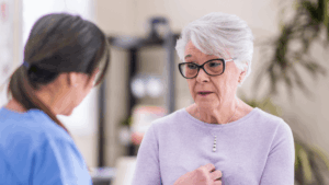 An elderly person speaks with their doctor