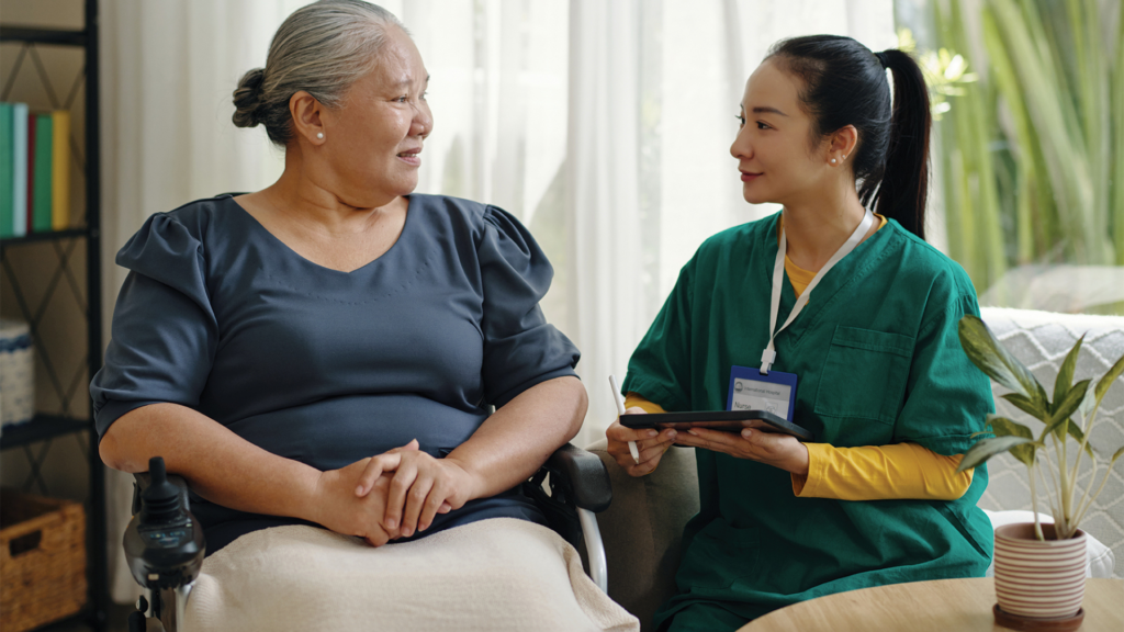 A nurse talking to a person in a wheelchair