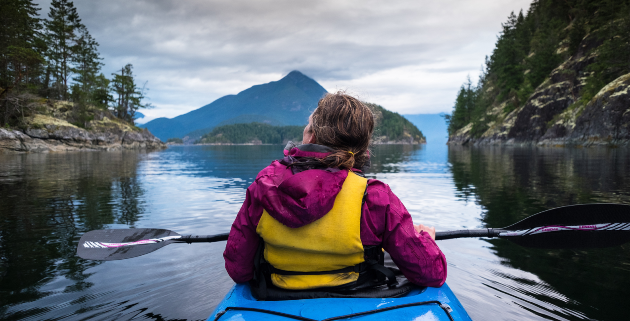 Main Image (2) A kayaking woman enjoying nature on a still lake