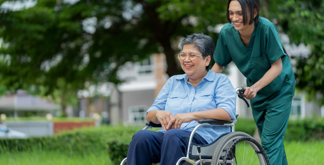 A care provider enjoying a conversations with a senior in a wheelchair